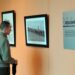 Marine 2nd Lt. Fernando Perez stops to admire the photographs in the “Focus on Ability: Celebrating Our Wounded, Ill and Injured Marines’ Achievements” exhibit at the National Museum of the Marine Corps in Triangle. Most of the photographs use selective color making the subject, a wounded Marine, standout from the background. (Mary Davidson/PotomacLocal.com)